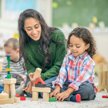 A teacher assisting a group of students in a classroom setting.